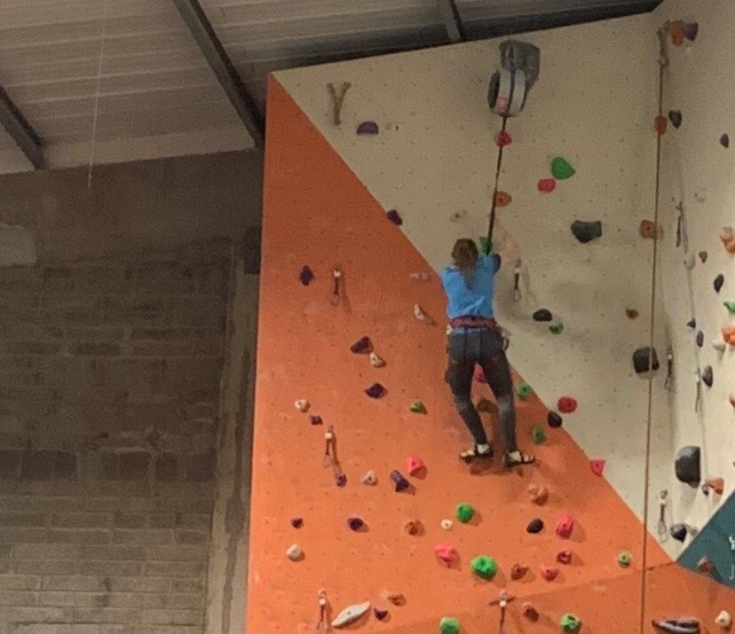 female climbing a climbing wall