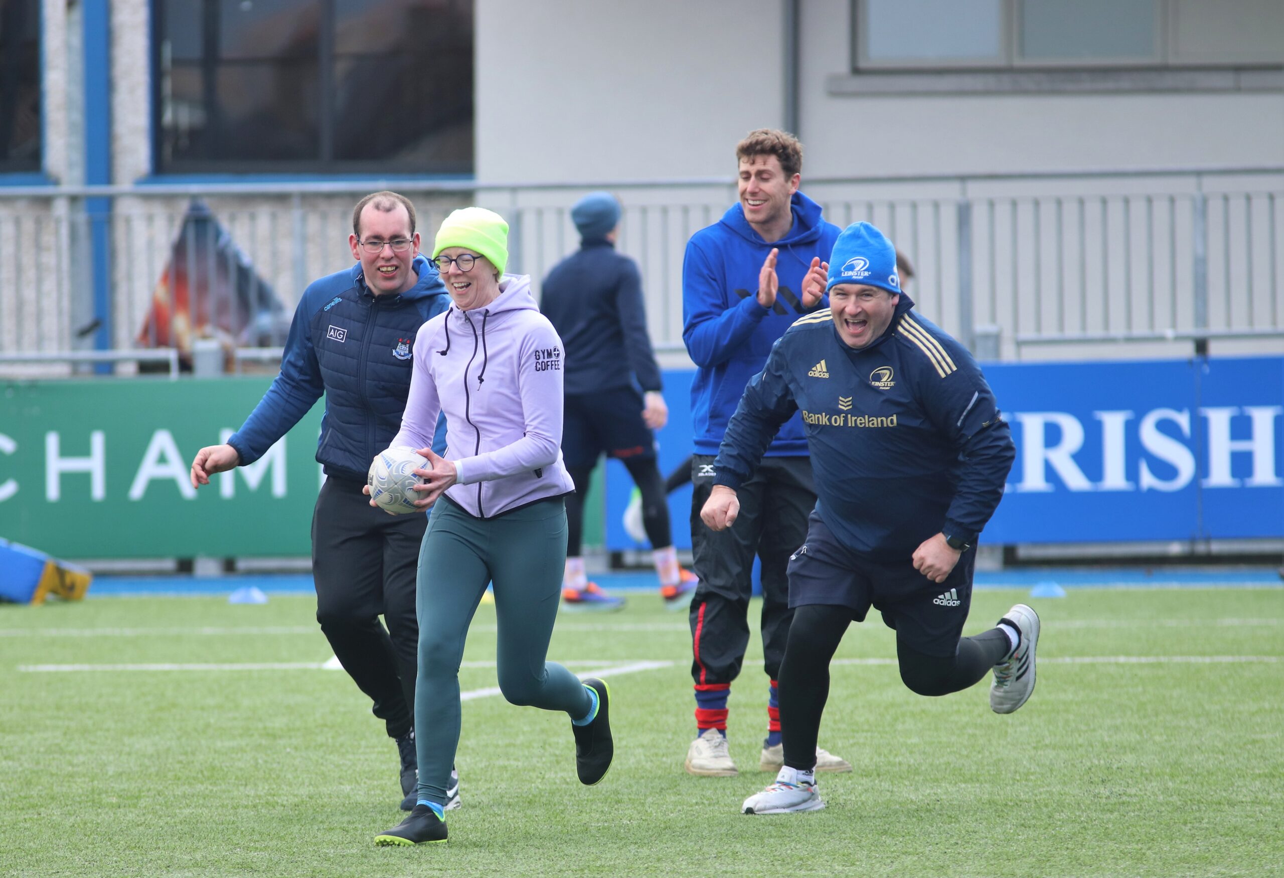 Photo of participants and coaches playing rugby.