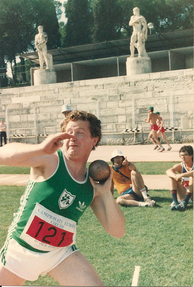 old photo of a male participant throwing a shotput