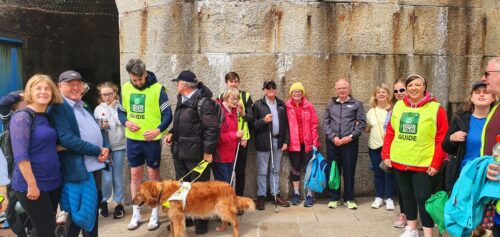 A large group of participants pose for a photo after a guided walk