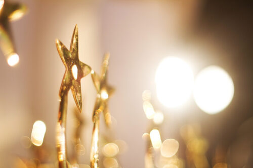 Image of a gold star trophy on warm lighting with spotlights