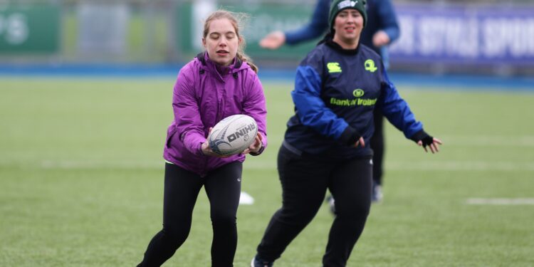 image of 2 participants running, one is holding a rugby ball