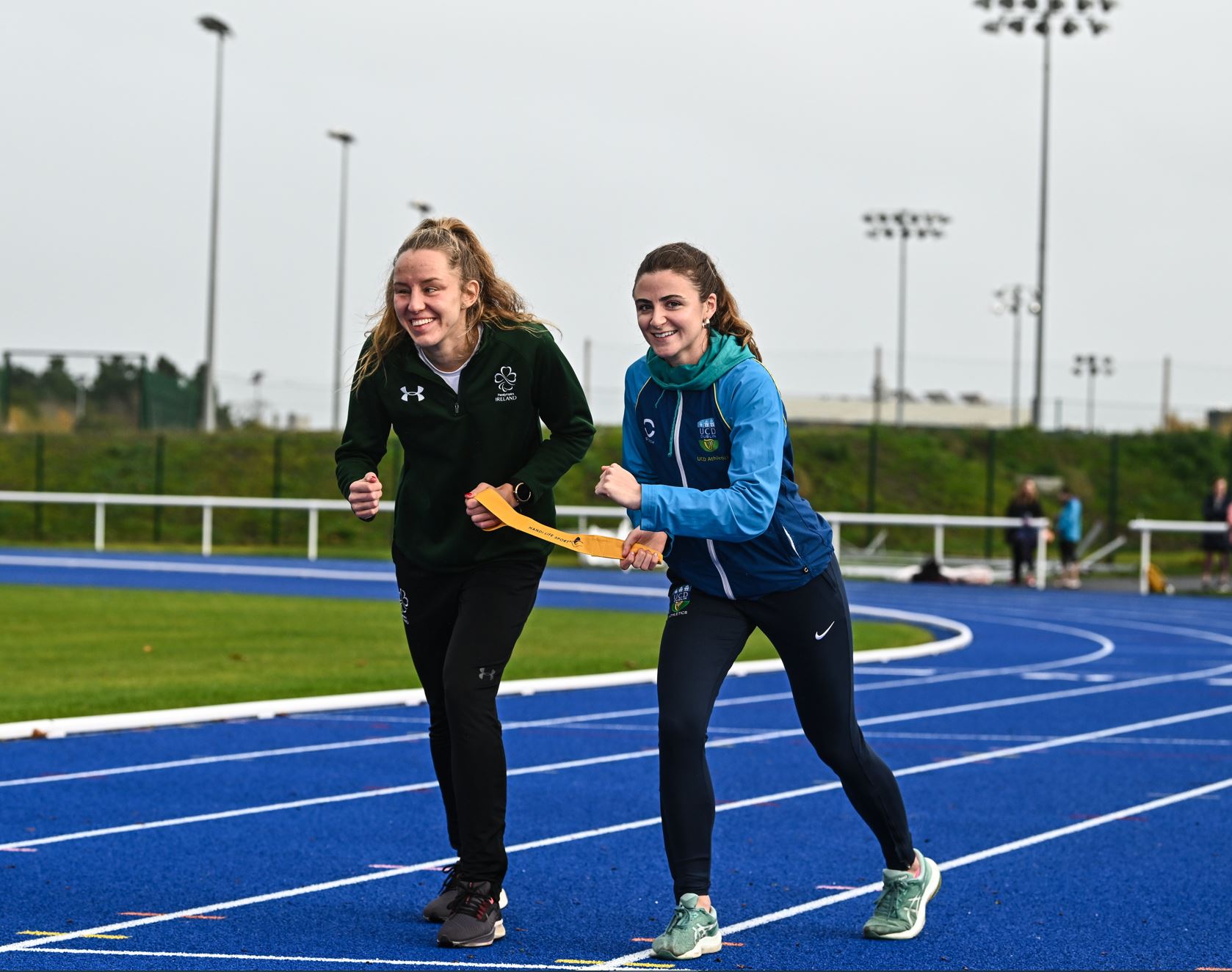 two females hold a tether and run on a running track