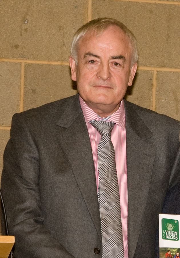 Image of a man with short grey hair wearing a suit.