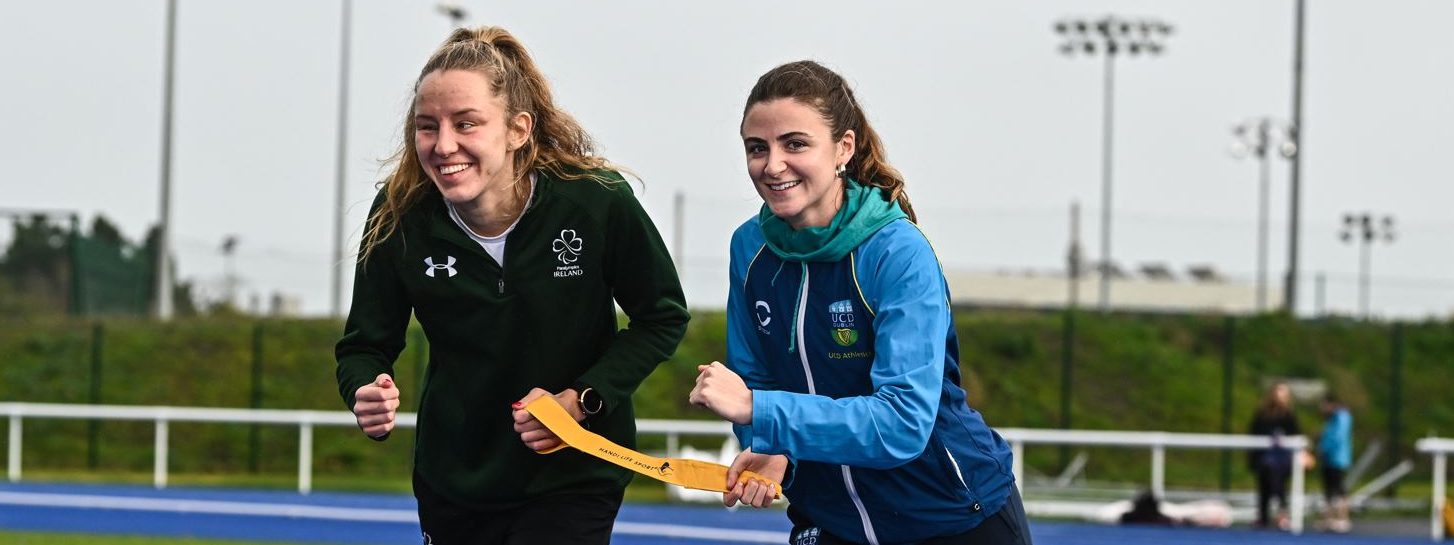 two females hold a tether and run on a running track