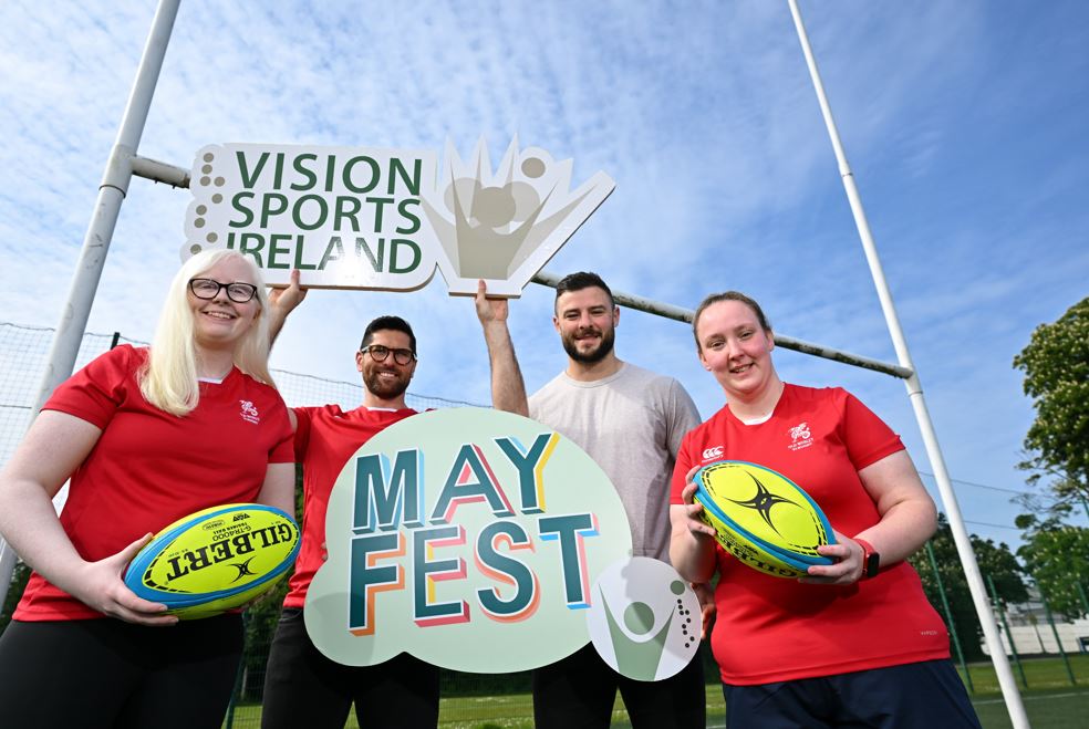 A group photo of Ian Mc Kinley, Robbie Henshaw and 2 female VI rugby players holding rugby balls and both Vision Sports Ireland and Mayfest logo signs