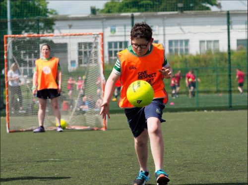 a child soloing the ball during a GAA session