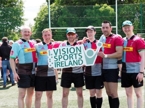 The Harlequins vi rugby team hold up a Vision Sports Ireland sign