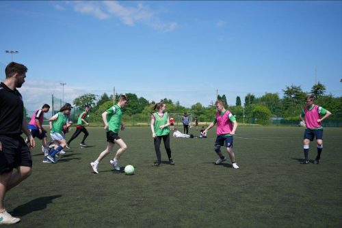 A football session with a player dribbling the ball towards another player
