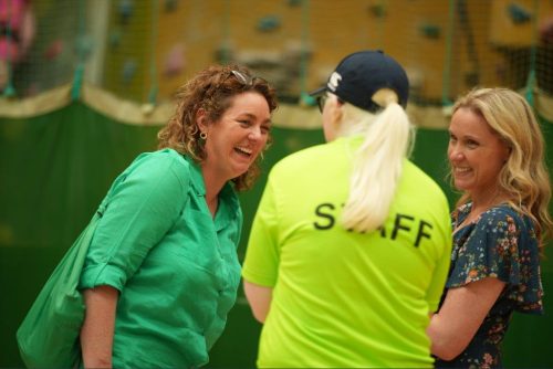 A woman smiling speaking to a staff member at Mayfest