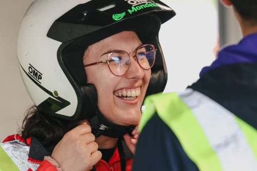 a volunteer laughing while putting on a helmet