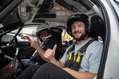 Robbie Henshaw sits in a rally car smiling at the camera and giving a thumbs up at #ZeroLimits23. The rally driver sits beside him and is also giving a thumbs up to the camera.
