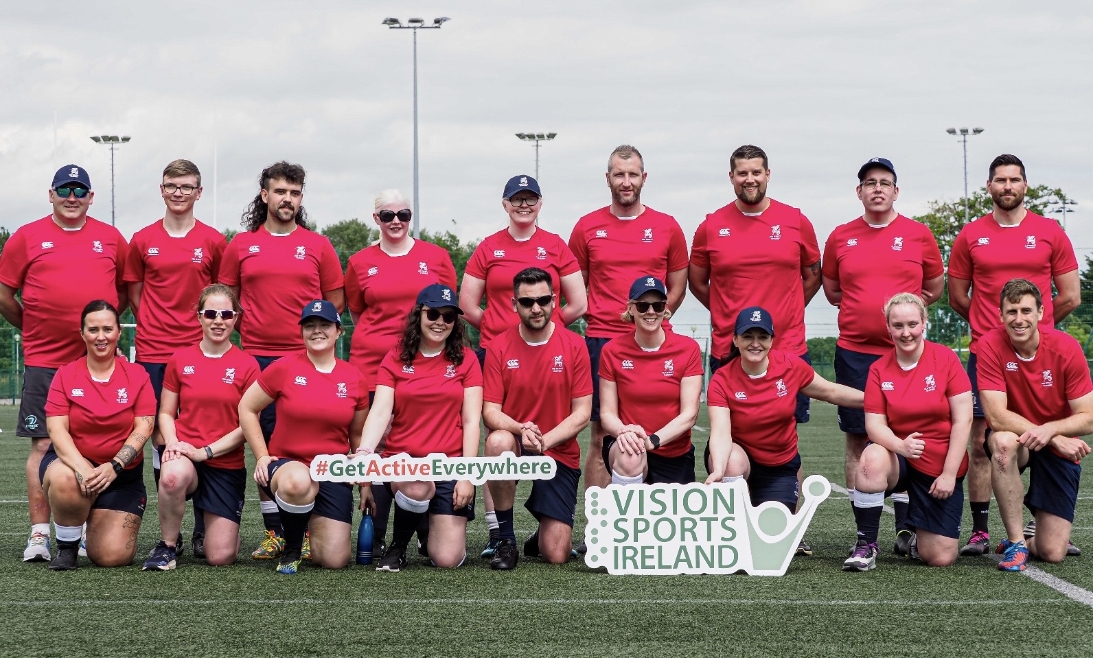 A group photo of the vi rugby team. The group are holding a Vision Sports Ireland sign and a #GetActiveEverywhere sign