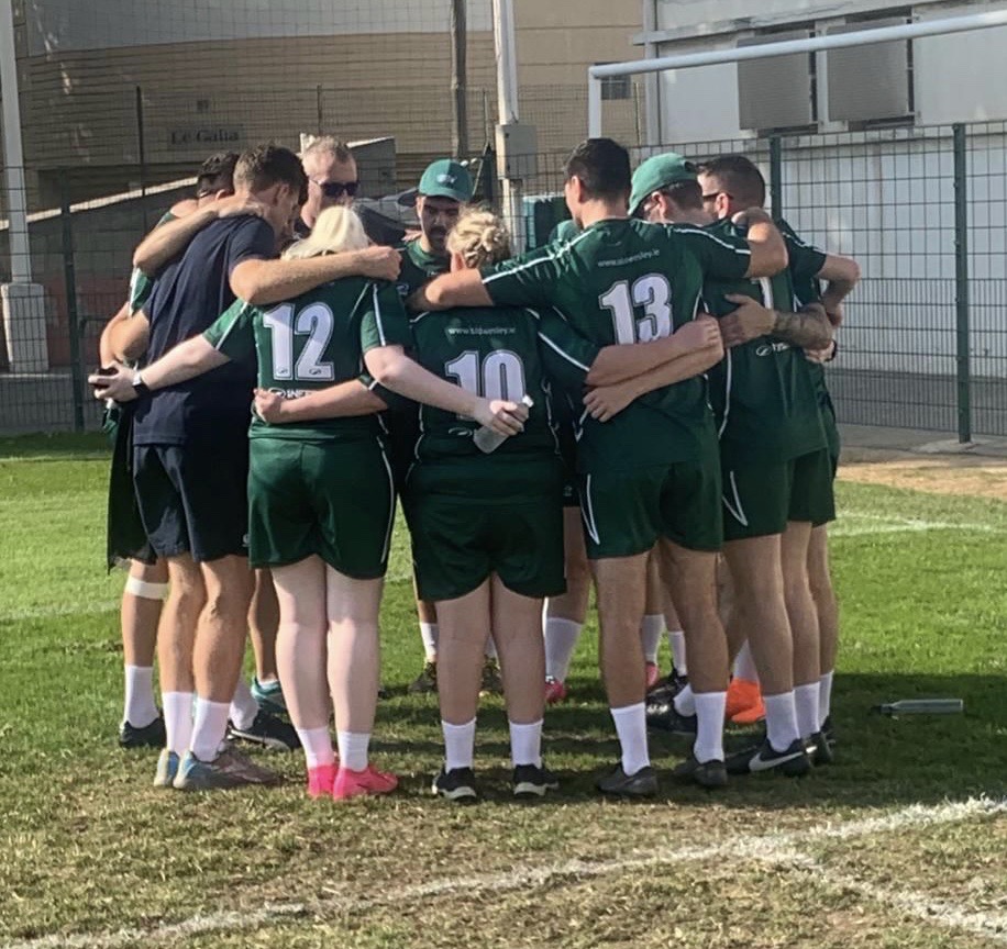 Players in a huddle wearing green kits