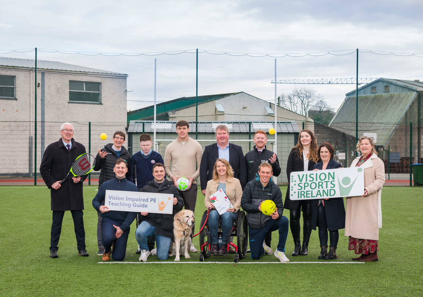 A group photo of from the Vision Impaired PE Teaching Guide launch. The group consists of Senator Martin Conway, Kerry footballer David Clifford, student Michael O Brien and representatives from Vision Sports Ireland, Kerry Local Sports Partnership, St Brendan’s College and the Steering Group which created the resource. The group are holding signs and sporting equipment.