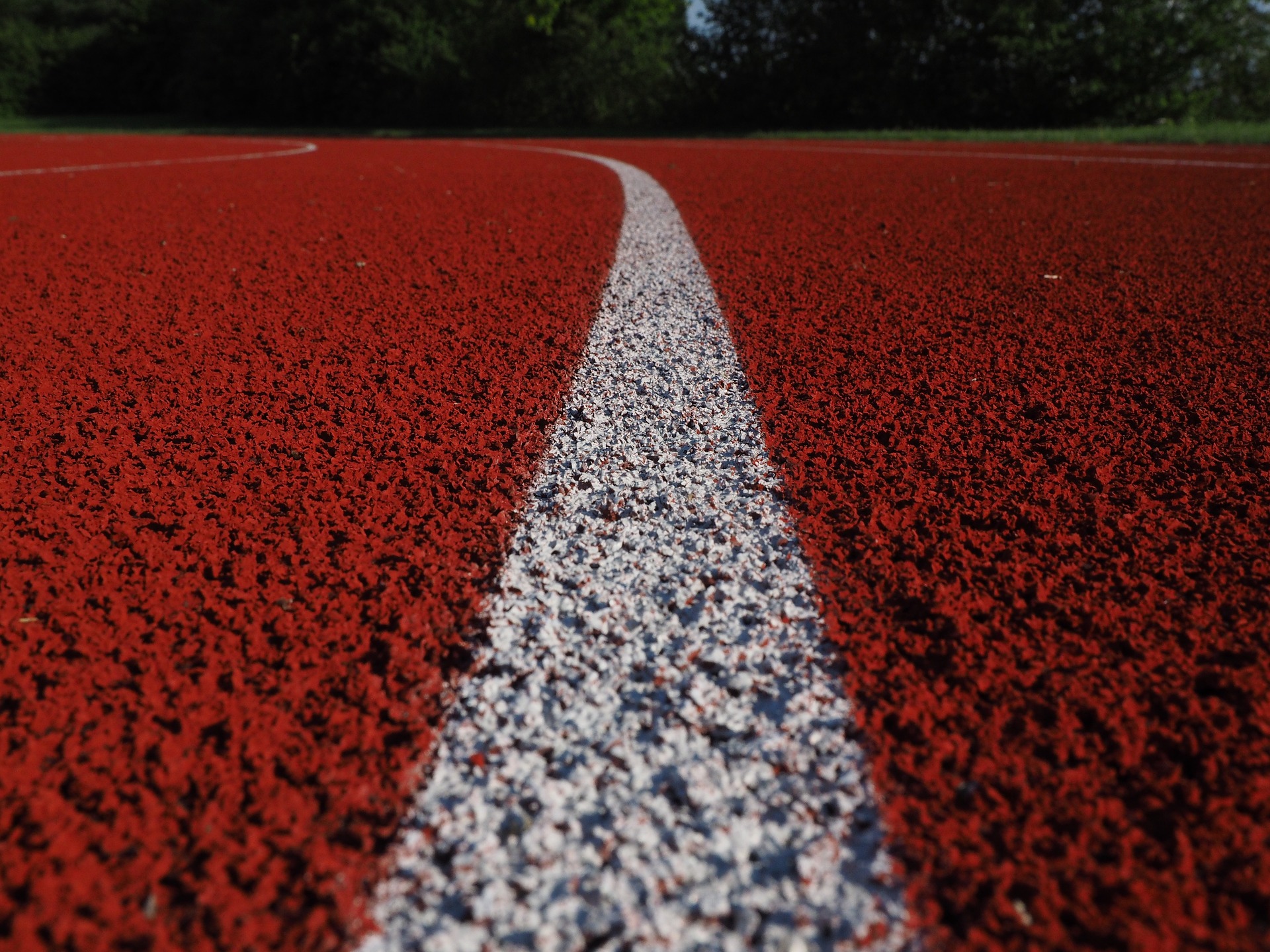 Close up of athletics track with white lane stripe in the middle