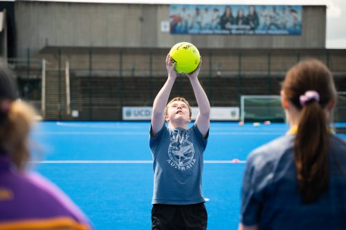 a young participant catches a ball during a GAA session
